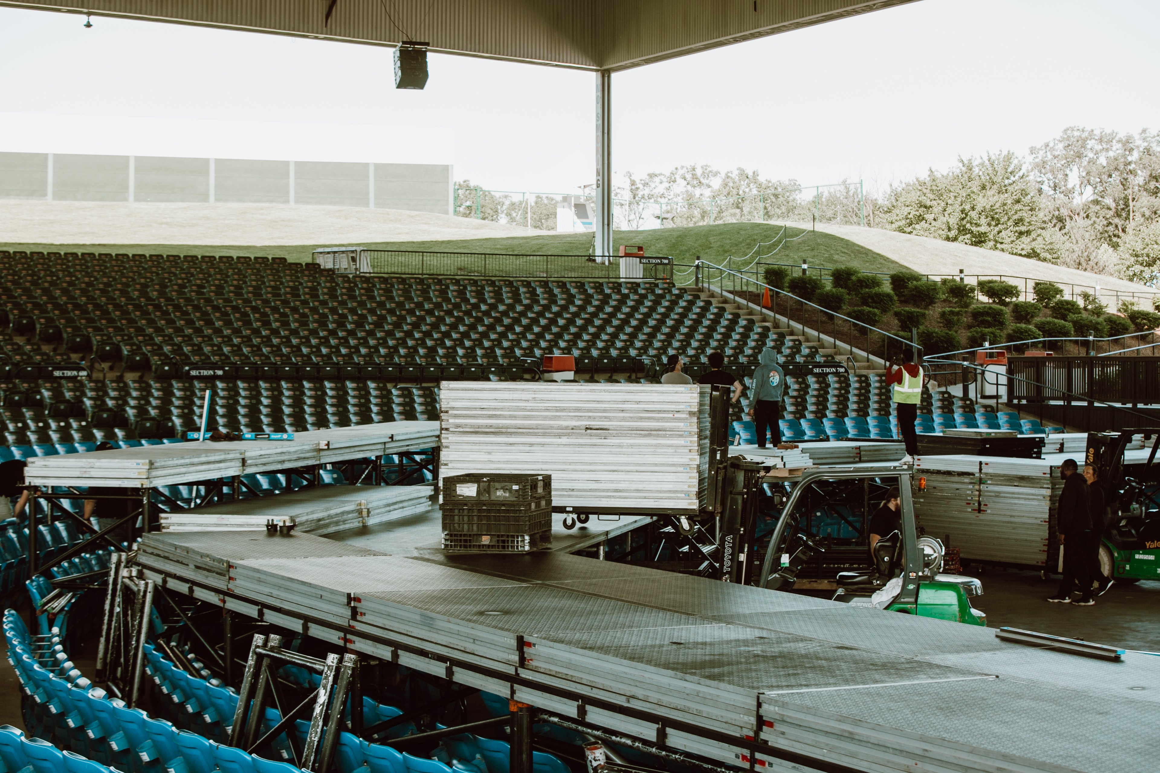 Tiered risers around a stage being set up.