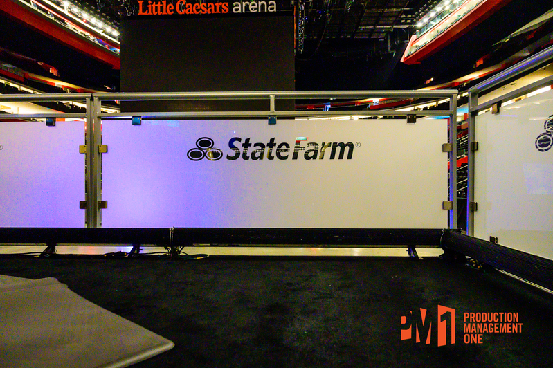 Clear stage deck railings with custom logos on a PM1 custom stage at Little Caesars Arena