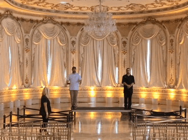 A production manager showing sightline to an end-user client in a gorgeous hotel ballroom at the Fontainebleau in Miami Beach, Florida for a political campaign event.