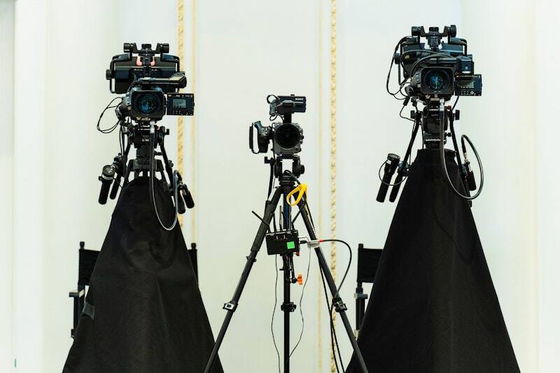 Three broadcast cameras on tripods, set for a PM1-produced forum in Washington, DC
