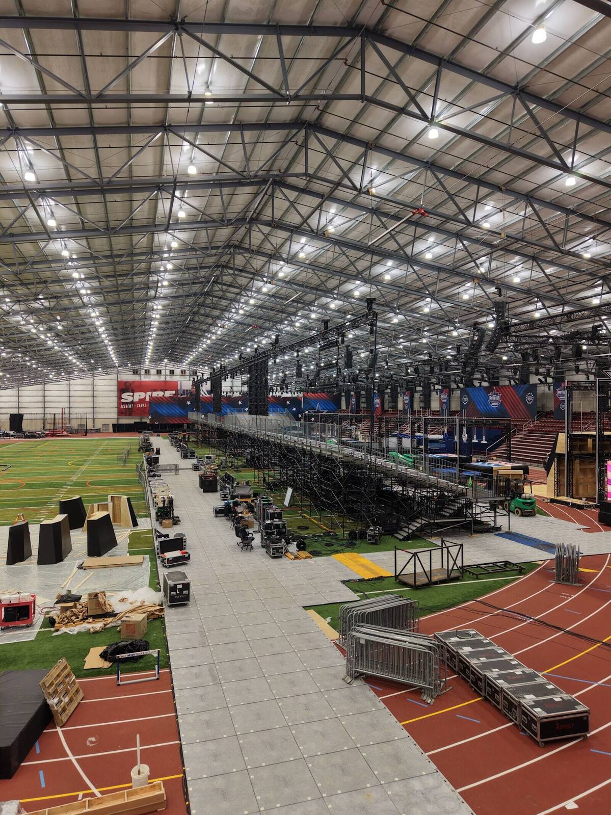 Overhead view of a PM1 load-in, with decking, cases, and structure staged in sequence on an indoor track