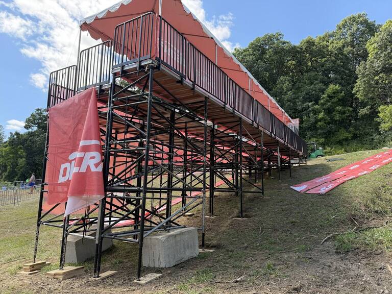 Temporary PM1 grandstand with a red canopy built on a grassy hillside