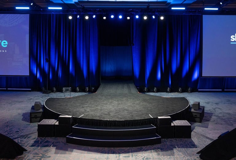 Indoor PM1 stage with a curved runway, side screens, and blue light