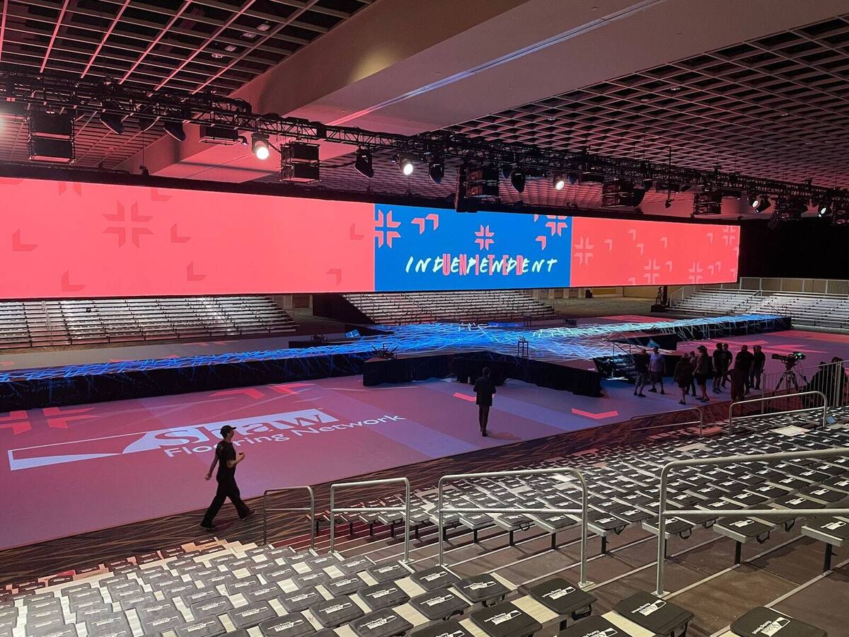 PM1 indoor stage with a red and blue INDEPENDENT backdrop and branded stage deck
