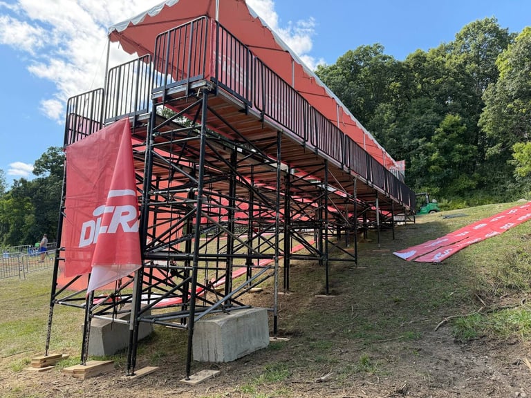 PM1 grandstand with a red canopy on a hillside at the 2026 PDGA Worlds