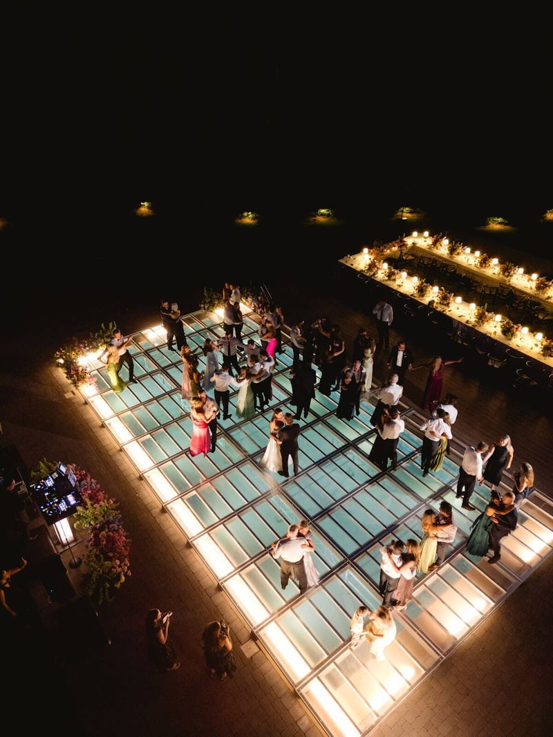 Couples dancing at night on an illuminated PM1 pool cover dance floor