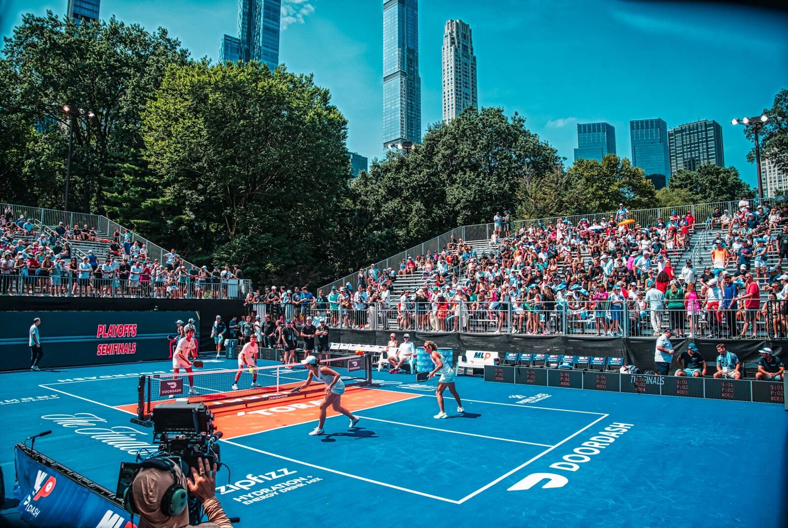 PM1 grandstands full of fans around a championship pickleball court in New York City, with the skyline behind